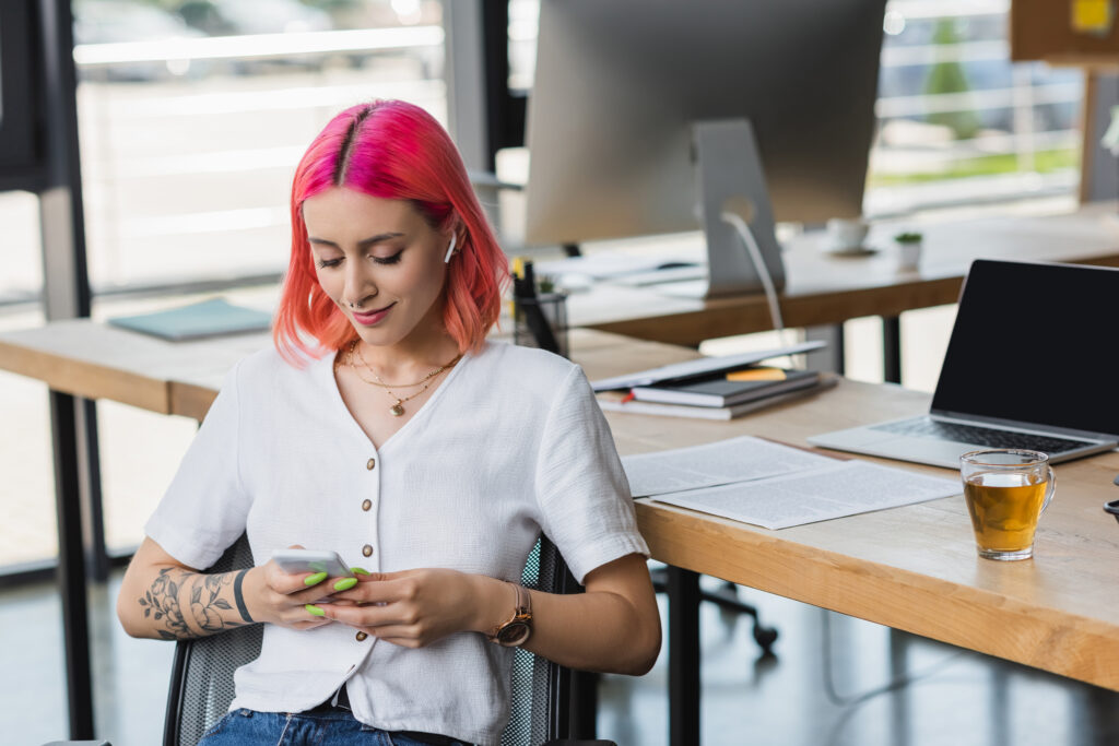 smiling young student with pink hair and earphones